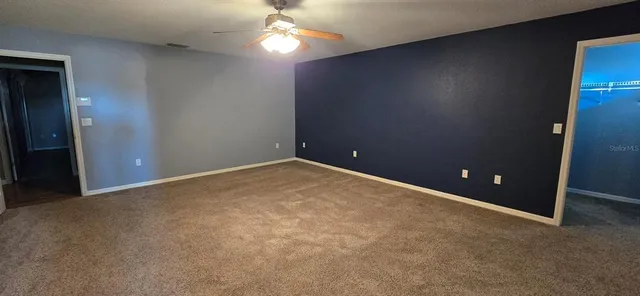 an empty room and chandelier fan