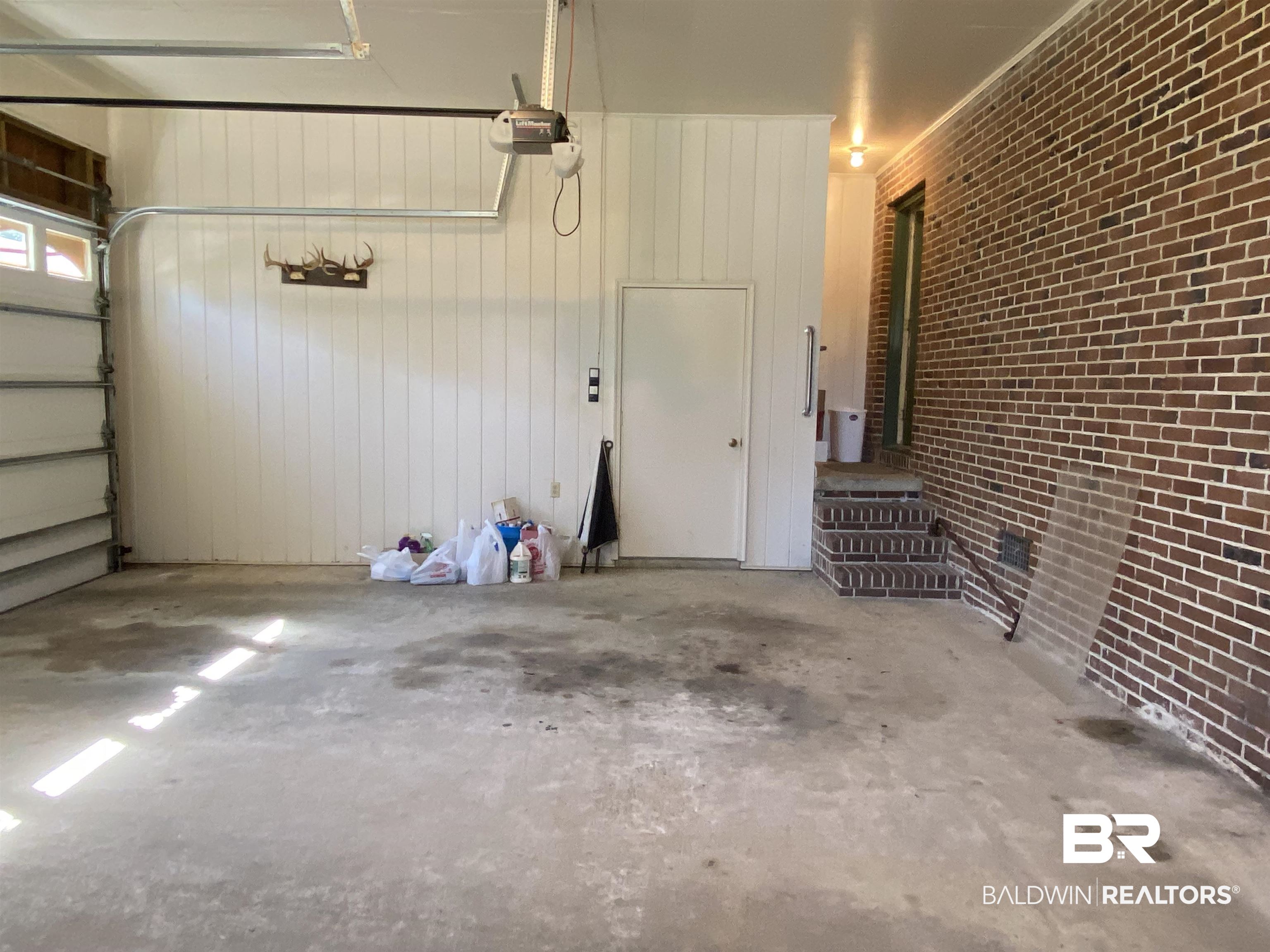 106 Terry Drive Brewton, AL 36426 - Photo 22 of 25 Garage featuring wood walls and a garage door opener