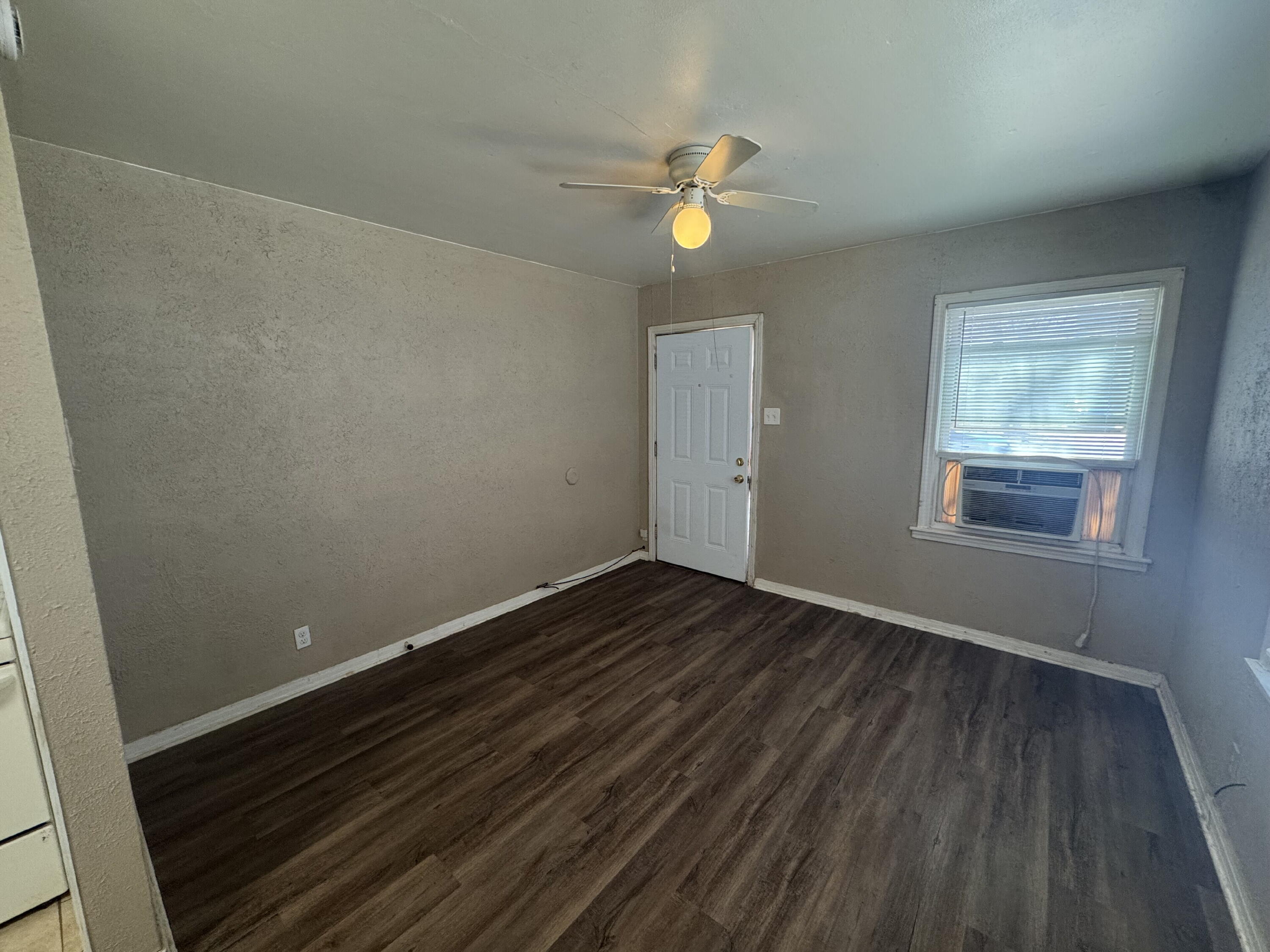 2118 33rd Street, Unit B Lubbock, TX 79411 - Photo 2 of 6 a view of an empty room with wooden floor and a window