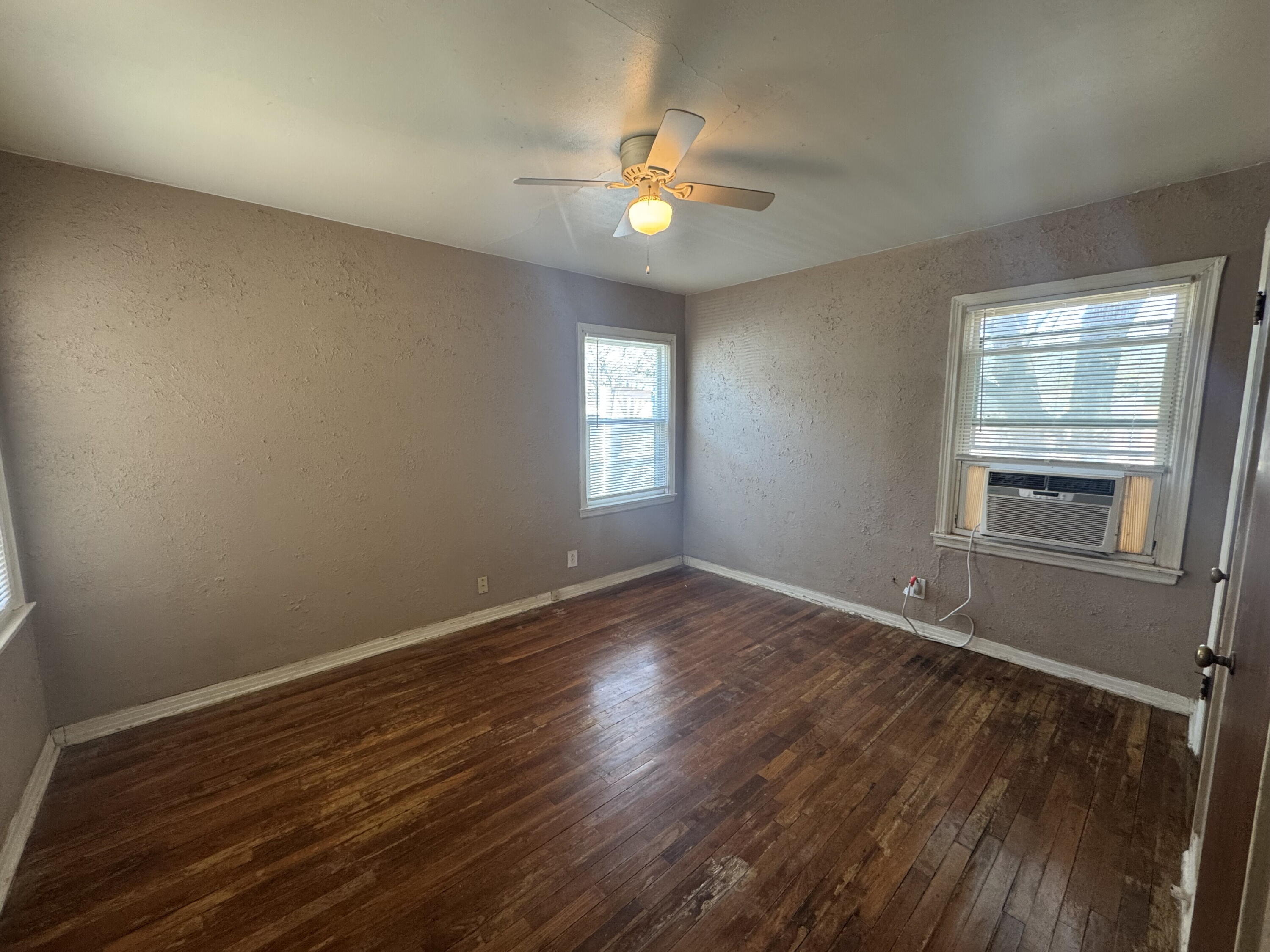 2118 33rd Street, Unit B Lubbock, TX 79411 - Photo 5 of 6 a view of an empty room with wooden floor and a window