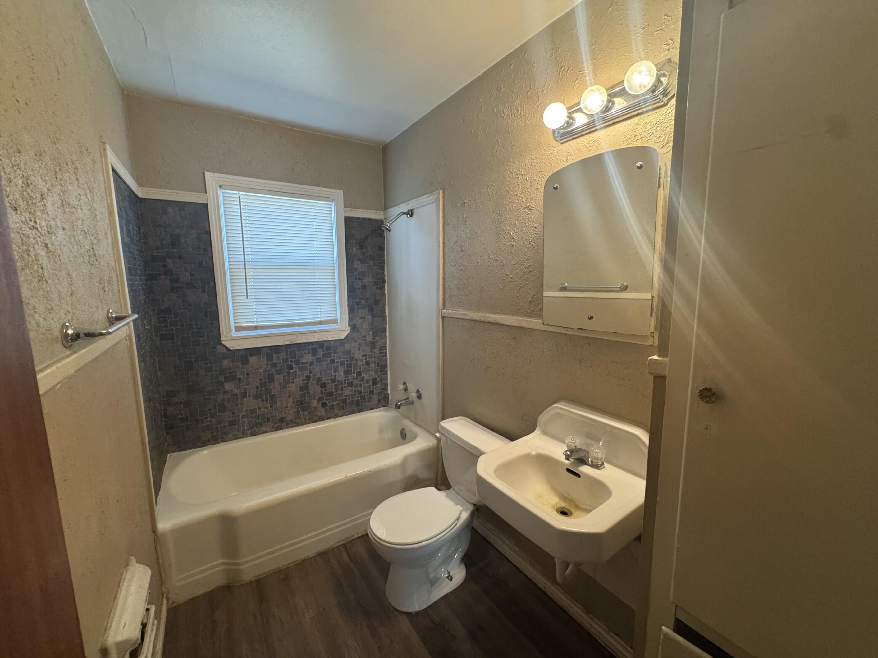 2118 33rd Street, Unit B Lubbock, TX 79411 - Photo 6 of 6 a bathroom with a sink toilet bathtub and shower