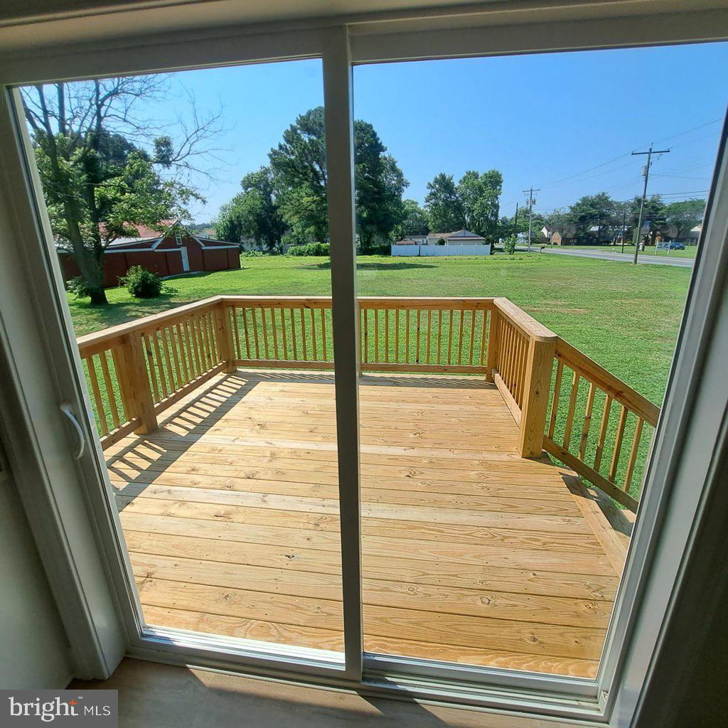 101 Thompson Street Hurlock, MD 21643 - Photo 4 of 16 a view of a wooden deck with a yard