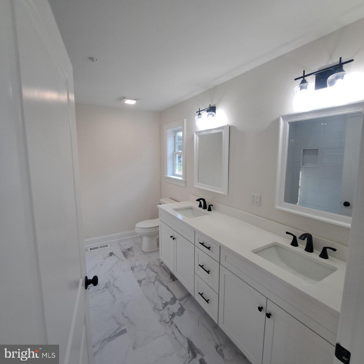 101 Thompson Street Hurlock, MD 21643 - Photo 9 of 16 a spacious bathroom with double vanity sink a mirror and a bathtub