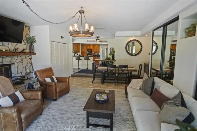 a living room with furniture a flat screen tv and kitchen view
