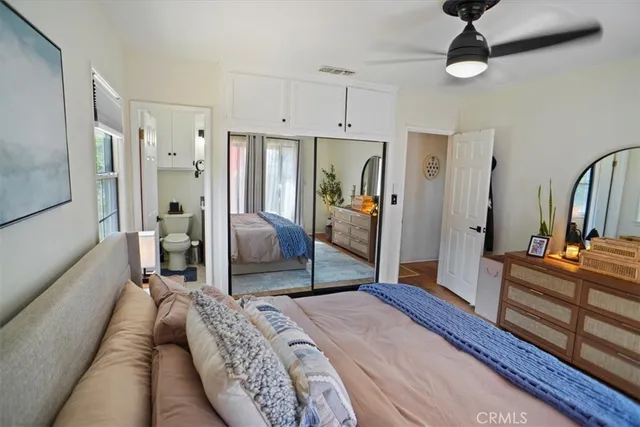 a bedroom with a bed a chandelier and dresser