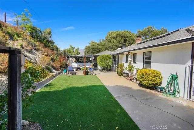 a view of a patio with table and chairs potted plants with large tree