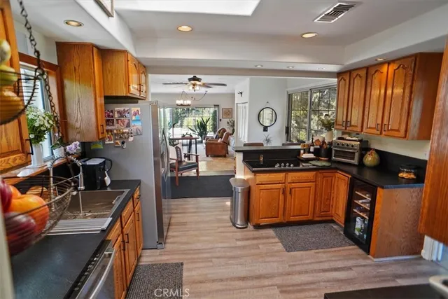 a large kitchen with stainless steel appliances granite countertop a stove a sink dishwasher and cabinets with wooden floor