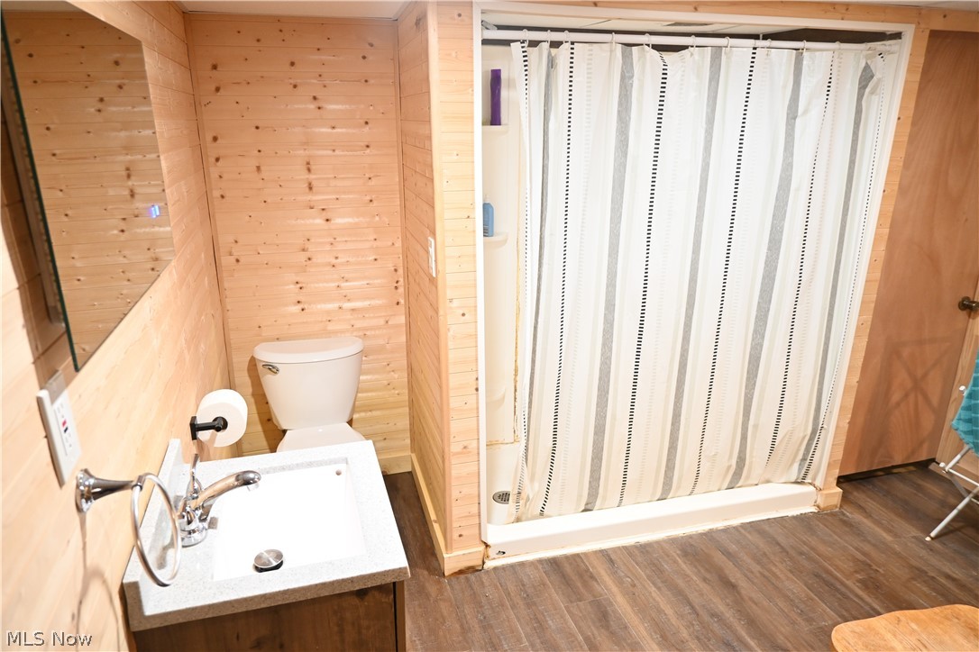 94 North 5th Street Rittman, OH 44270 - Photo 19 of 27 Full bath with wood walls, a stall shower, vanity, and wood style flooring