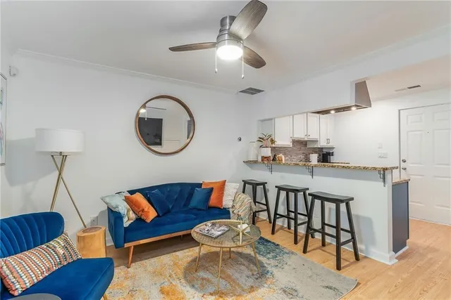 a living room with stainless steel appliances kitchen island a table and a couch