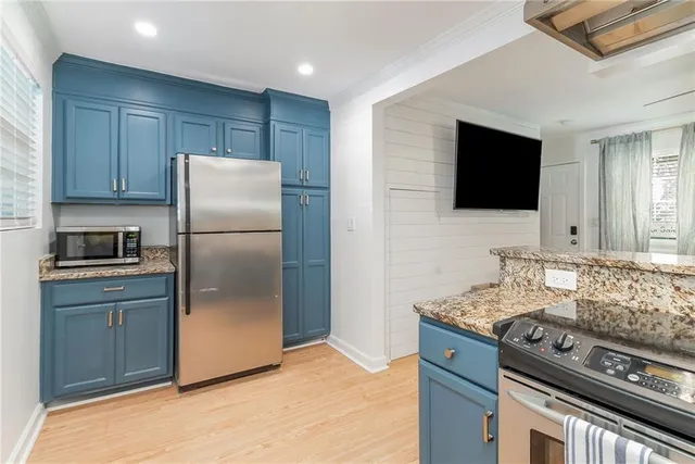 a kitchen with granite countertop a refrigerator stove and kitchen island