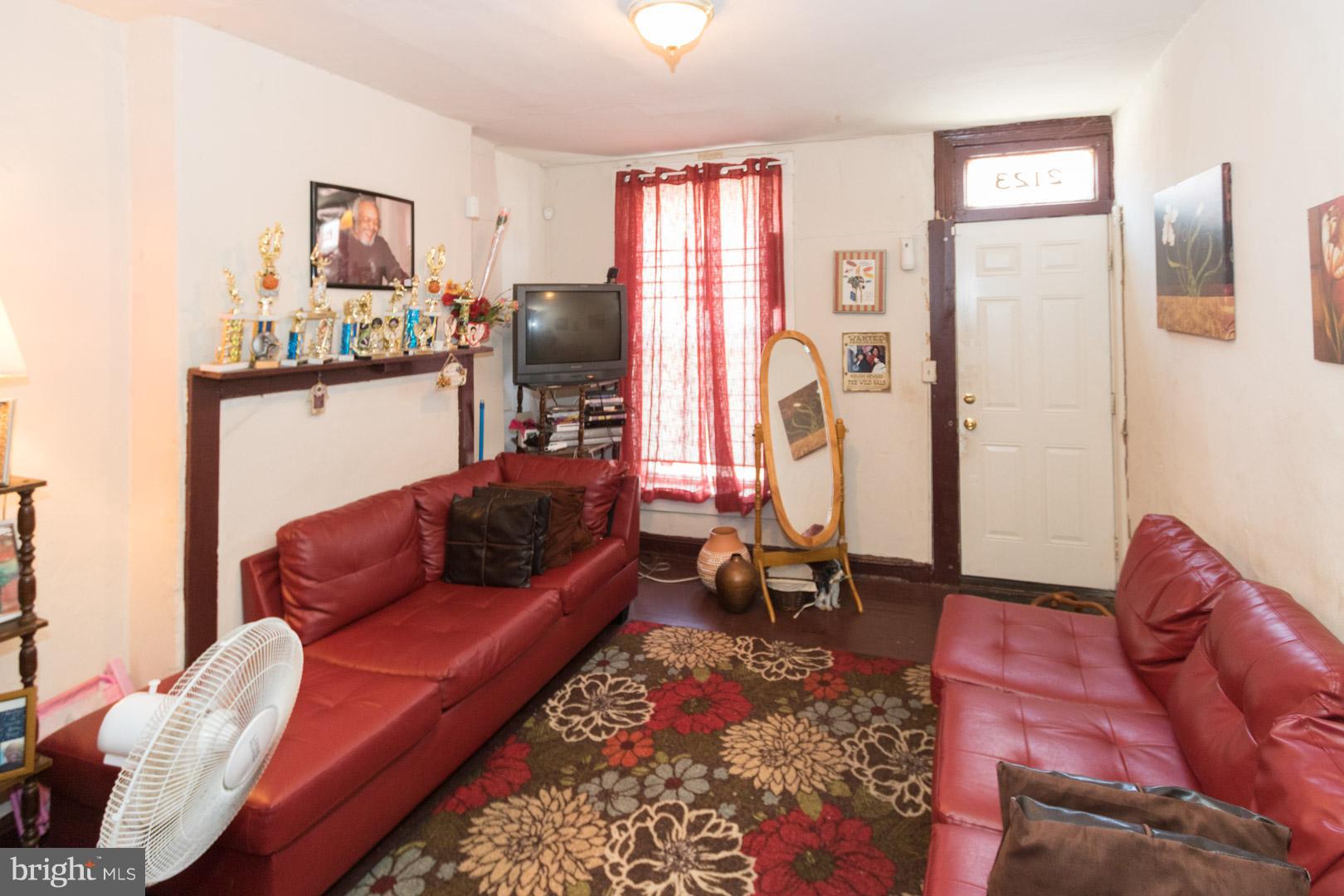 2123 East Chase Street Baltimore, MD 21213 - Photo 2 of 12 a living room with furniture ceiling fan and a rug