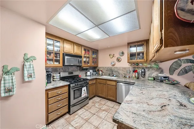 a kitchen with stainless steel appliances granite countertop a sink stove and cabinets