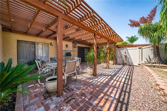 a view of a patio with table and chairs potted plants and palm trees