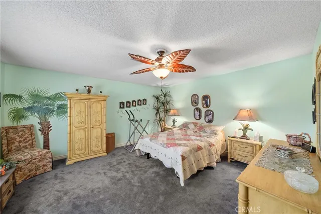a bedroom with a bed dresser and a flat tv screen