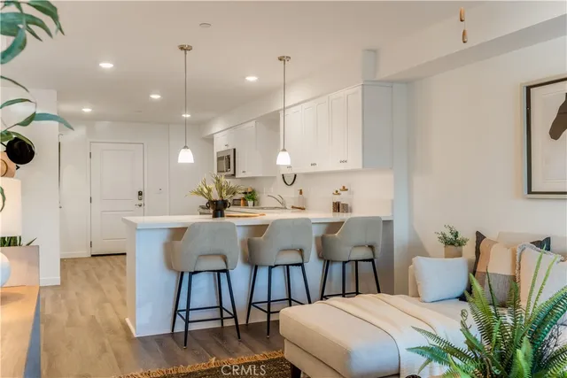 a living room with furniture and a view of kitchen