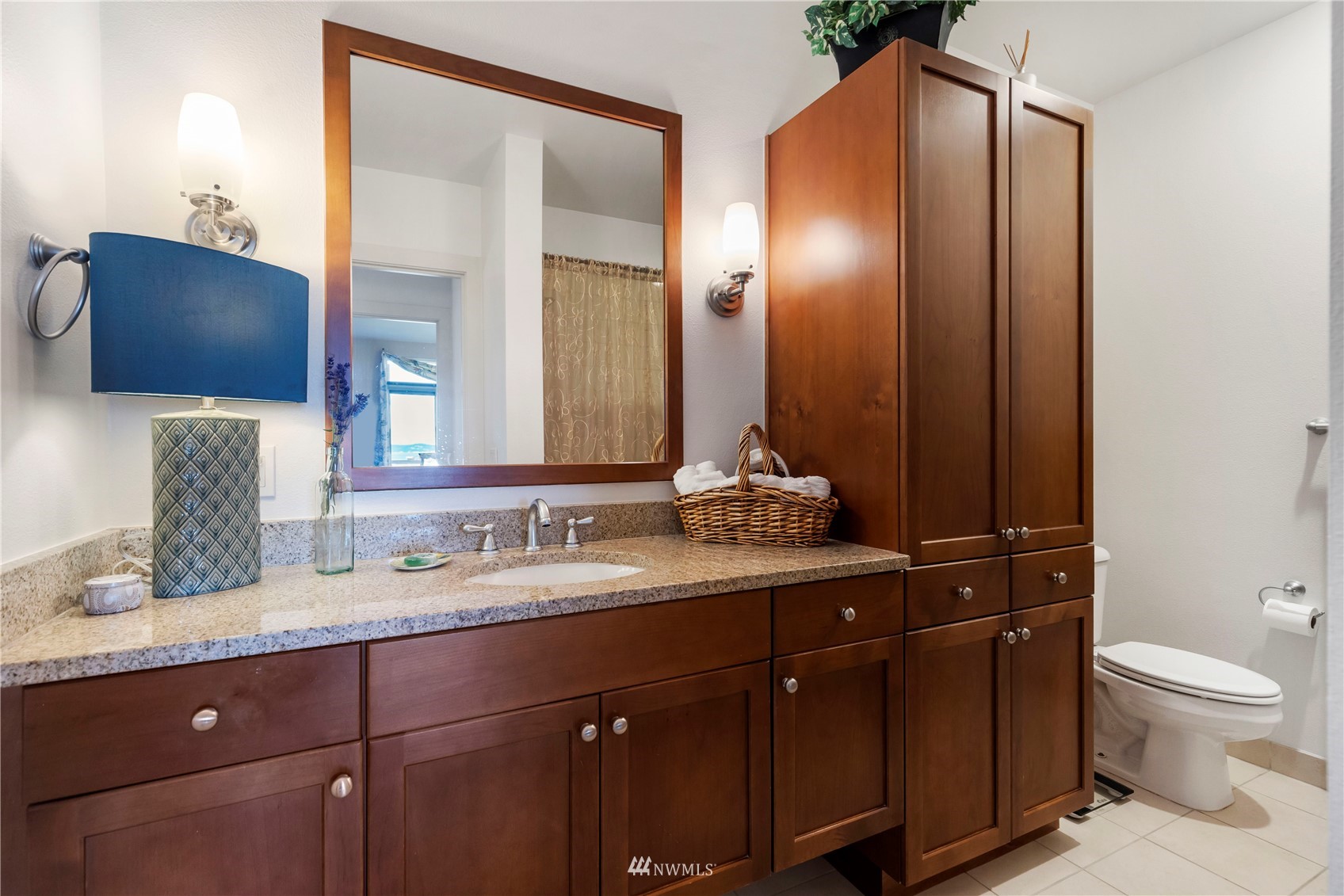 75 Pine Street, Unit 205 Edmonds, WA 98020 - Photo 19 of 33 a bathroom with a granite countertop sink a toilet and a mirror