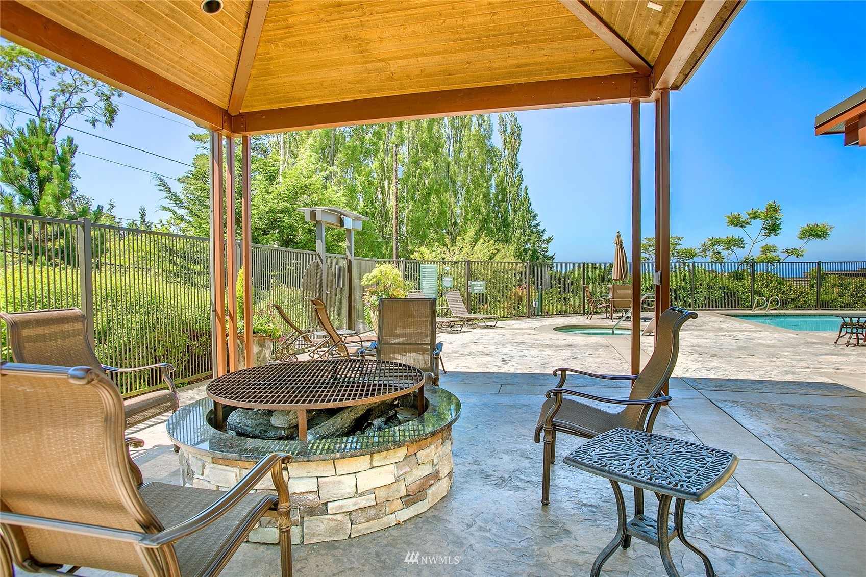 75 Pine Street, Unit 205 Edmonds, WA 98020 - Photo 26 of 33 a view of a patio with table and chairs potted plants and palm tree