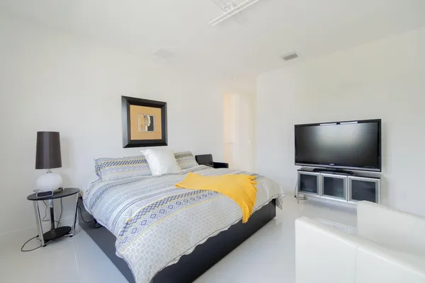 a bedroom with a bed and a flat screen tv