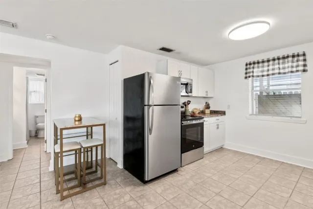 a kitchen with granite countertop a refrigerator stove top oven and sink