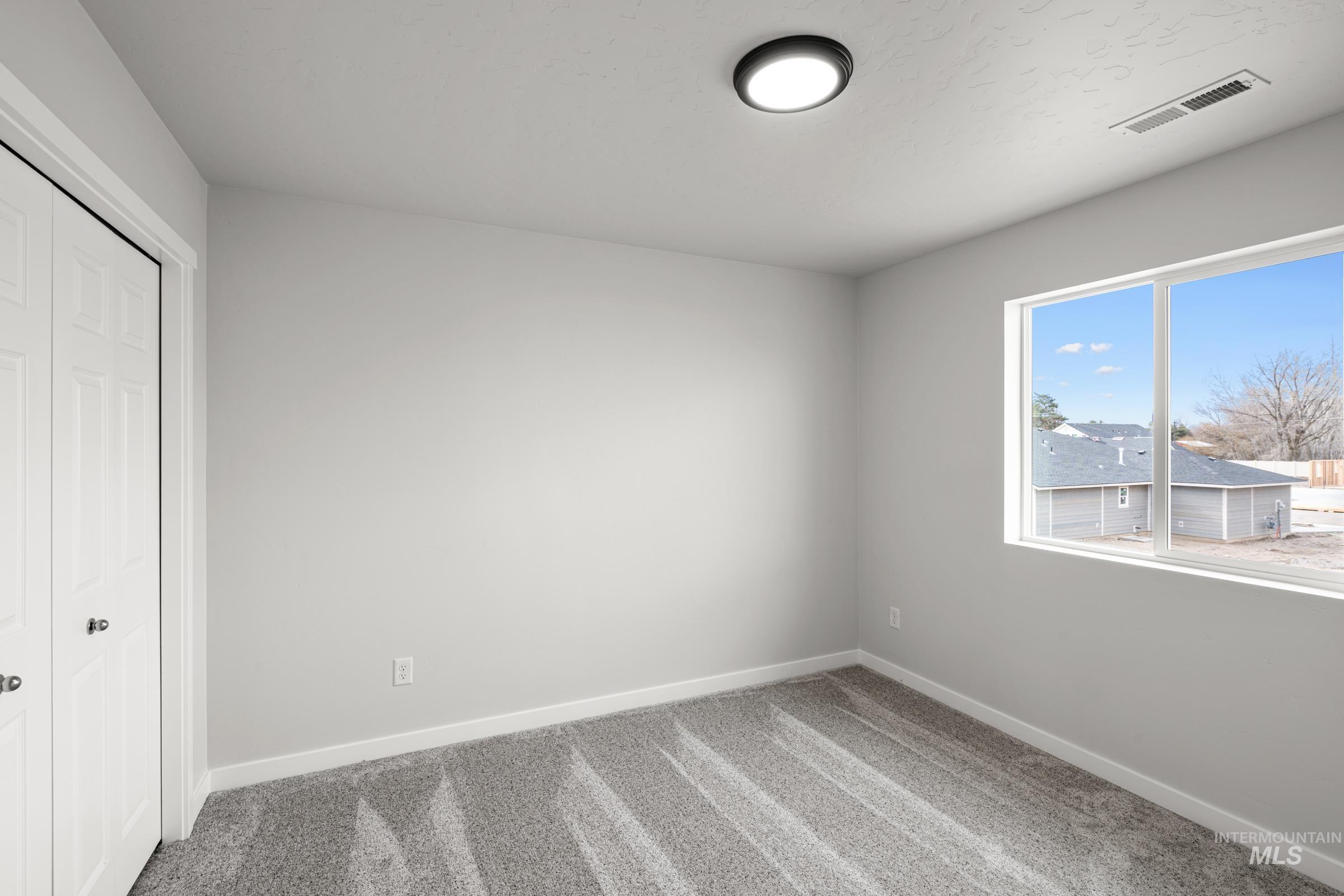14056 Shiny Spruce Street Caldwell, ID 83607 - Photo 14 of 25 Bedroom featuring light gray walls, gray carpet, white baseboards, and a large window