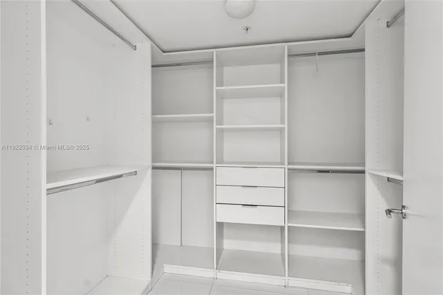 a view of walk in closet with empty racks