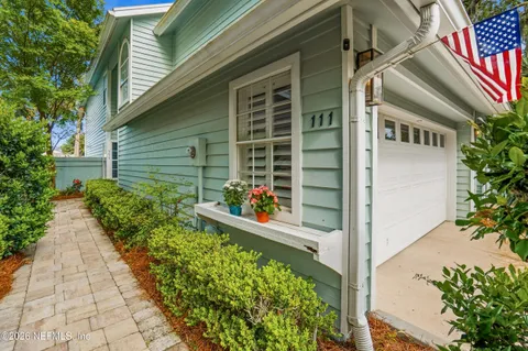 a dining room with wooden floor a chandelier a wooden table and chairs