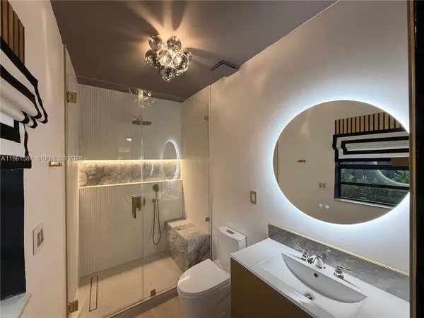 a bathroom with a sink a toilet a mirror and shower