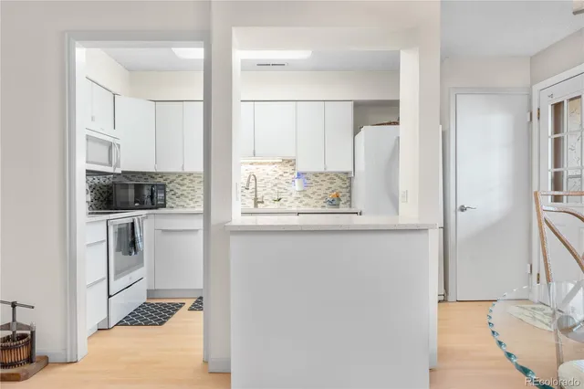 a view of kitchen with wooden floor and electronic appliances