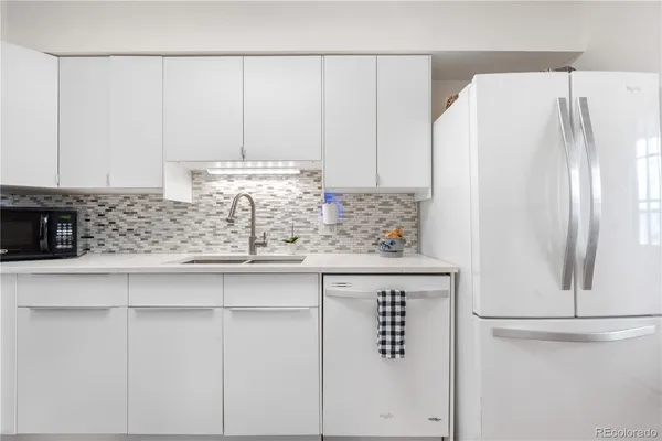 a kitchen with white cabinets and white appliances