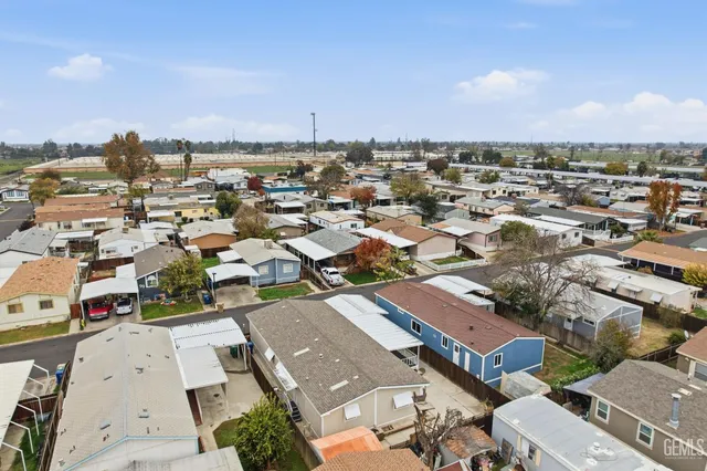 an aerial view of a city with lots of residential buildings and mountain view in back