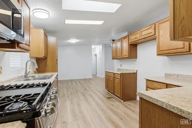 a kitchen with granite countertop a sink stove and cabinets