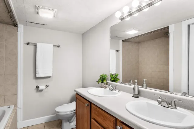 a bathroom with a granite countertop sink a toilet and a mirror