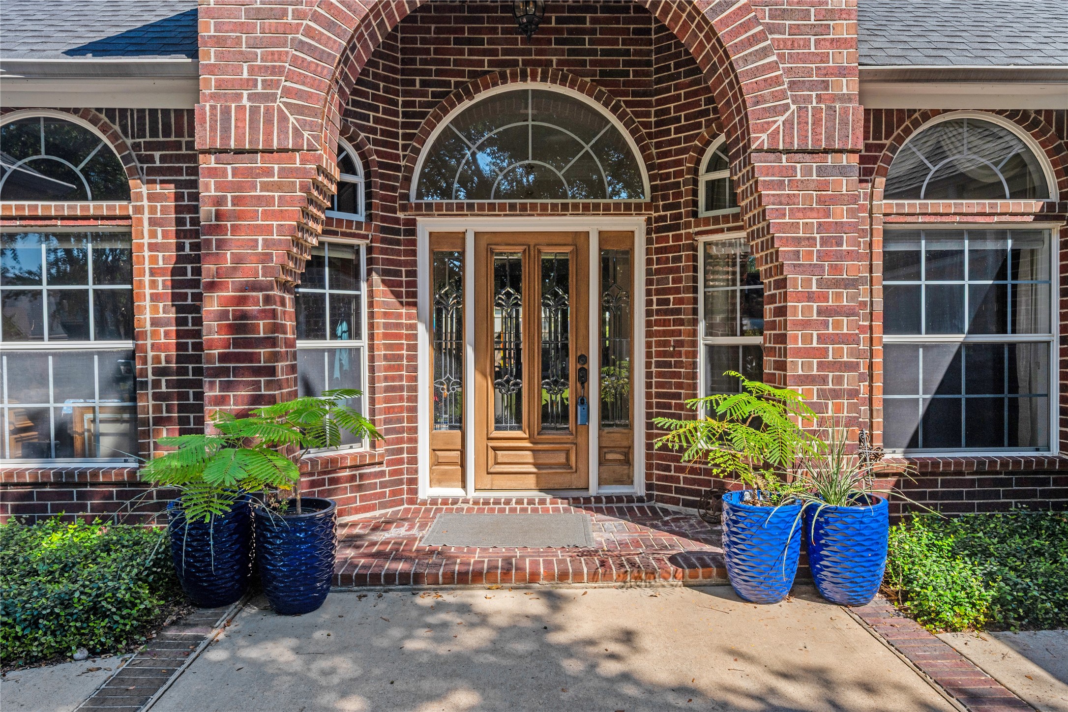 319 Palais Verde Road Montgomery, TX 77356 - Photo 4 of 39 Charming brick home entrance featuring an elegant arched doorway flanked by large windows.