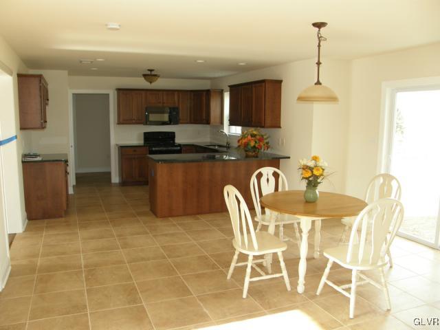 233 East Dell Road Bath, PA 18014 - Photo 11 of 13 a kitchen with stainless steel appliances granite countertop a sink a stove a dining table and chairs