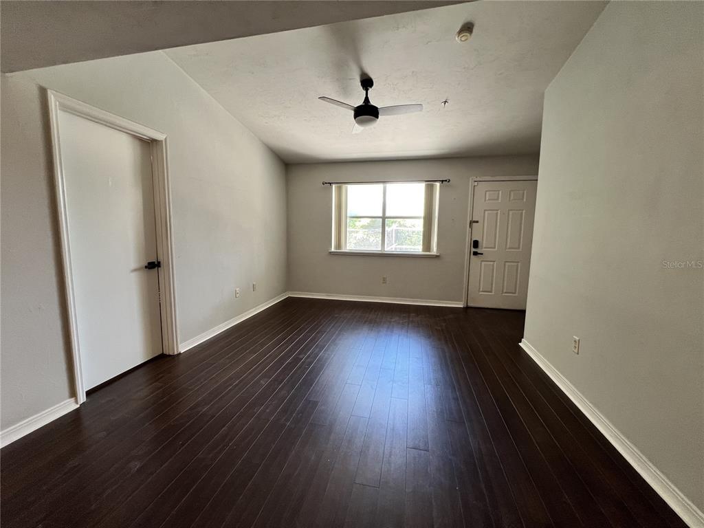 2360 Southwest Archer Road, Unit 719 Gainesville, FL 32608 - Photo 3 of 15 an empty room with wooden floor and windows