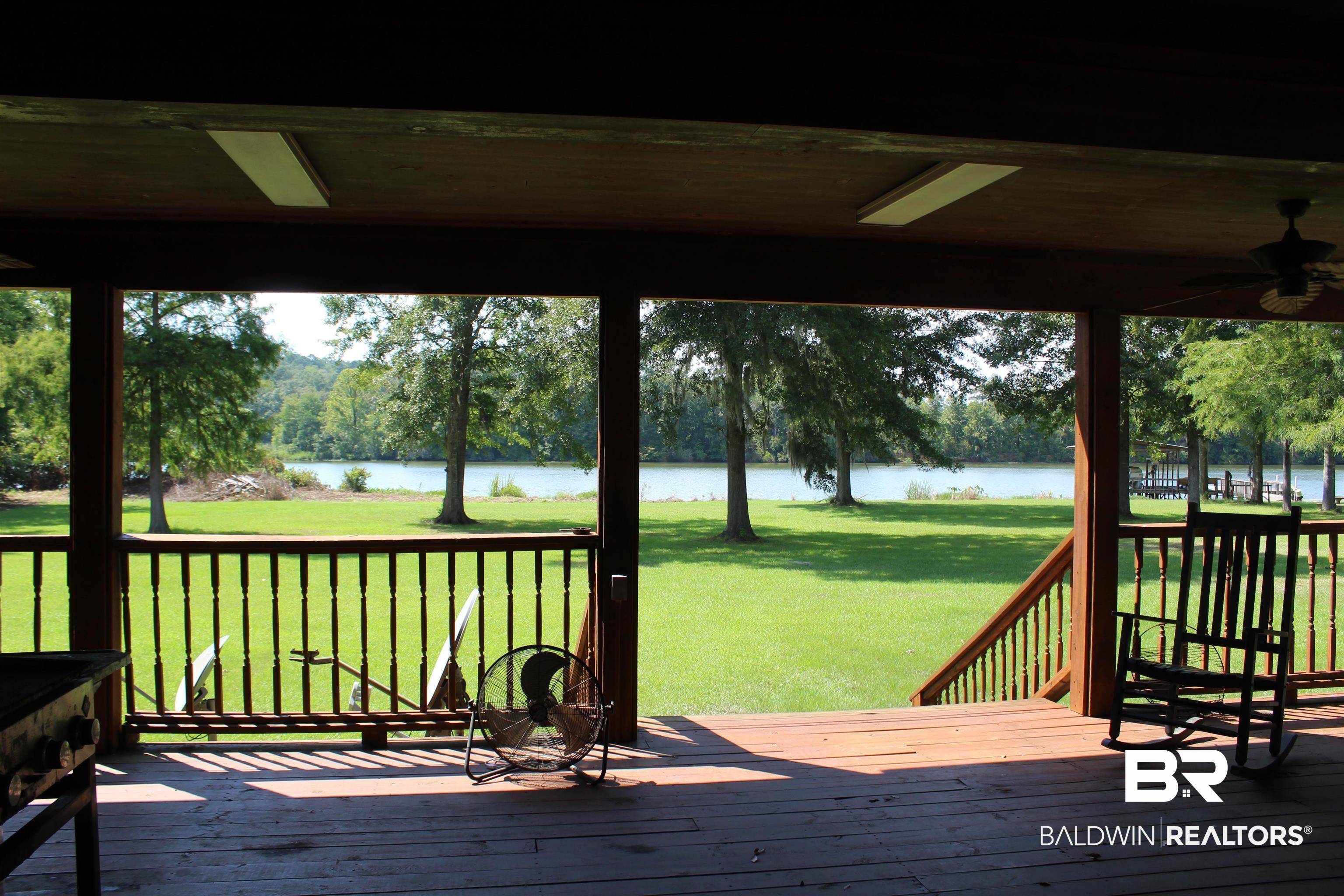 7258 Henderson Road Lowndesboro, AL 36752 - Photo 9 of 22 Deck with a water view, ceiling fan, a lawn, and view of wooded area