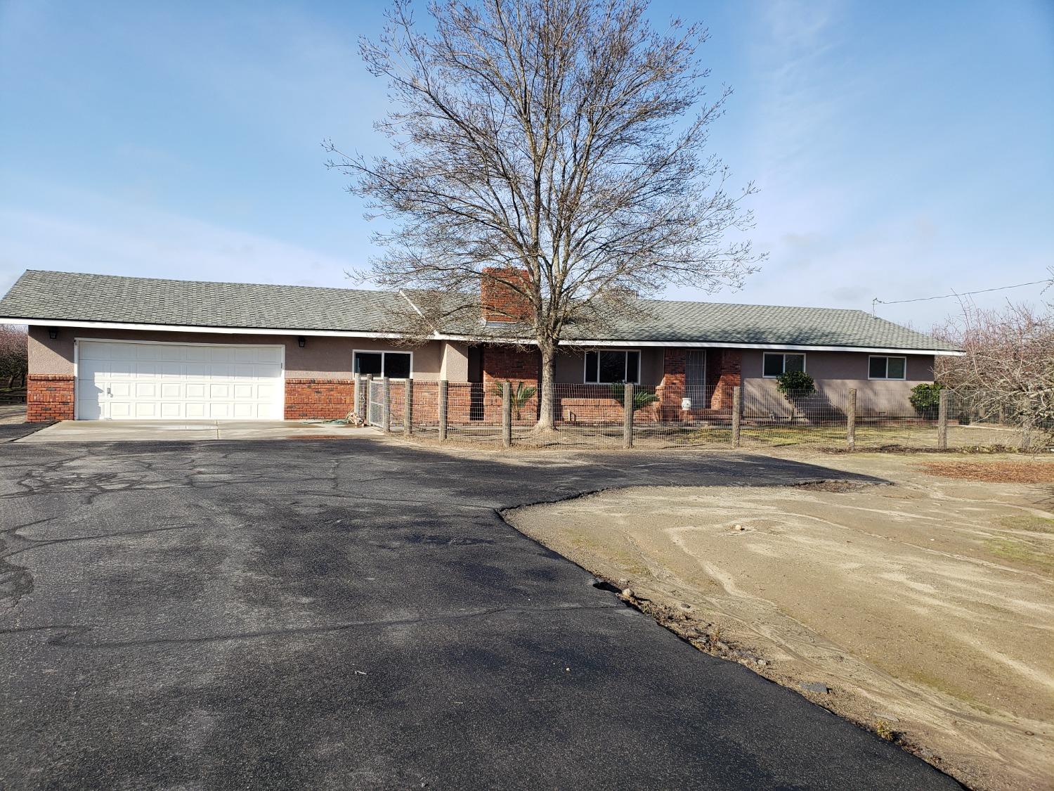 a front view of a building with large trees
