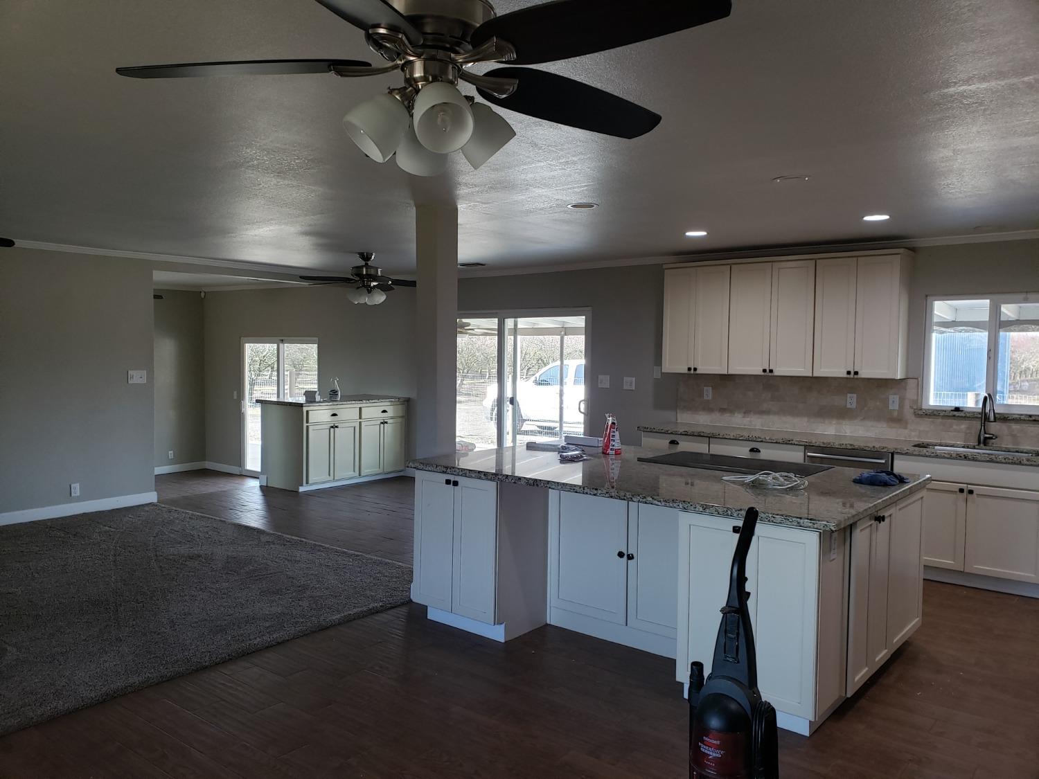 5658 Road 28 Madera, CA 93637 - Photo 2 of 11 an open kitchen with kitchen island white cabinetry and stainless steel appliances