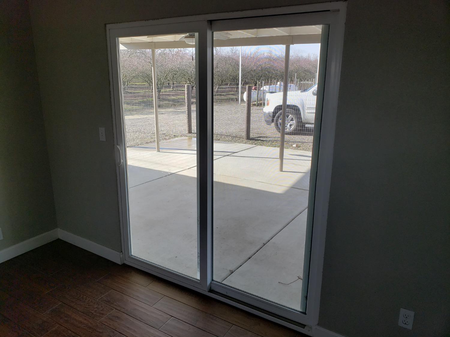5658 Road 28 Madera, CA 93637 - Photo 5 of 11 an empty room with wooden floor and door
