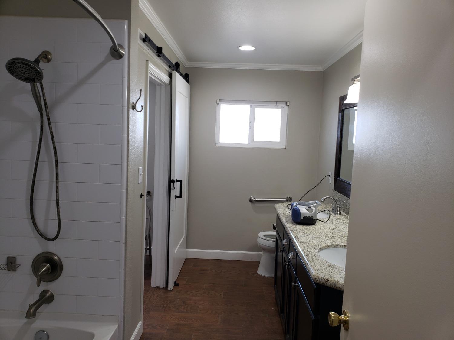 5658 Road 28 Madera, CA 93637 - Photo 7 of 11 a bathroom with a granite countertop sink a toilet and shower
