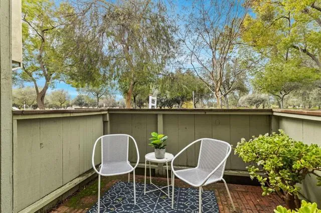 a table and chairs in patio next to a lake