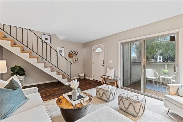 a living room with furniture and a dining table with balcony view
