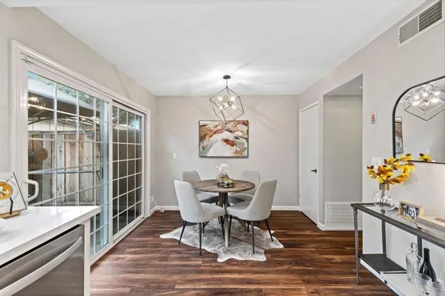 a dining room with wooden floor and a chandelier