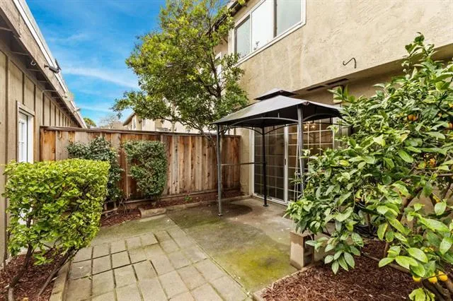 a view of a chair and table in the backyard of the house