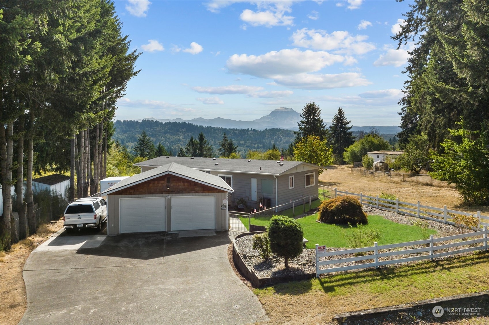 a view of a white house with a yard and sitting area