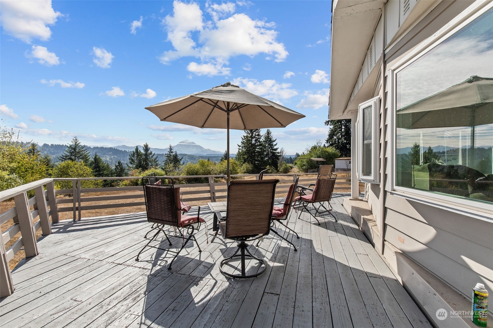 13909 Prairie Ridge Drive East Bonney Lake, WA 98391 - Photo 21 of 36 a view of a roof deck with table and chairs under an umbrella with wooden floor