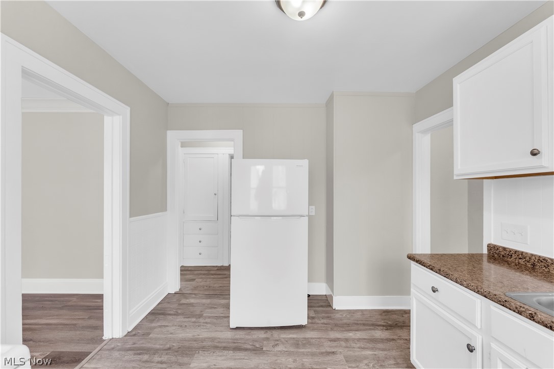 18123 McCracken Road Maple Heights, OH 44137 - Photo 12 of 27 Kitchen featuring white cabinetry, dark speckled countertops, and wood-finish flooring