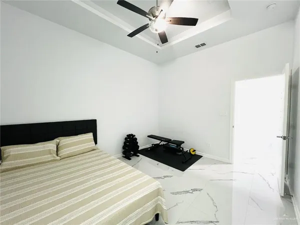 a bedroom with a bed and a ceiling fan