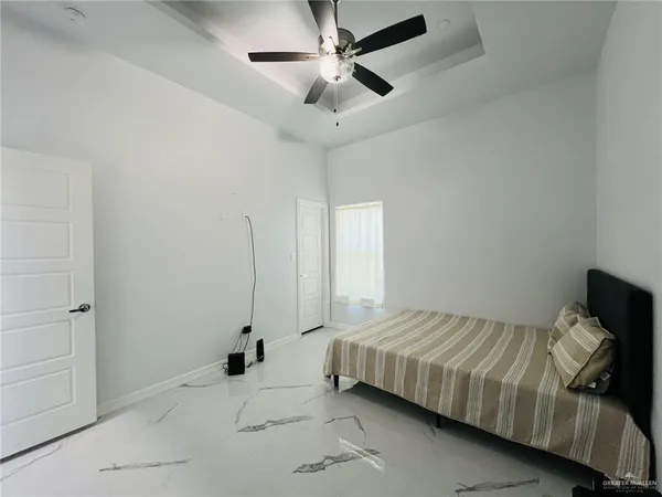 a bedroom with a bed and a ceiling fan