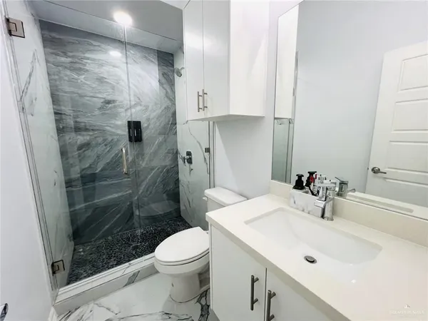 a bathroom with a sink a toilet and shower